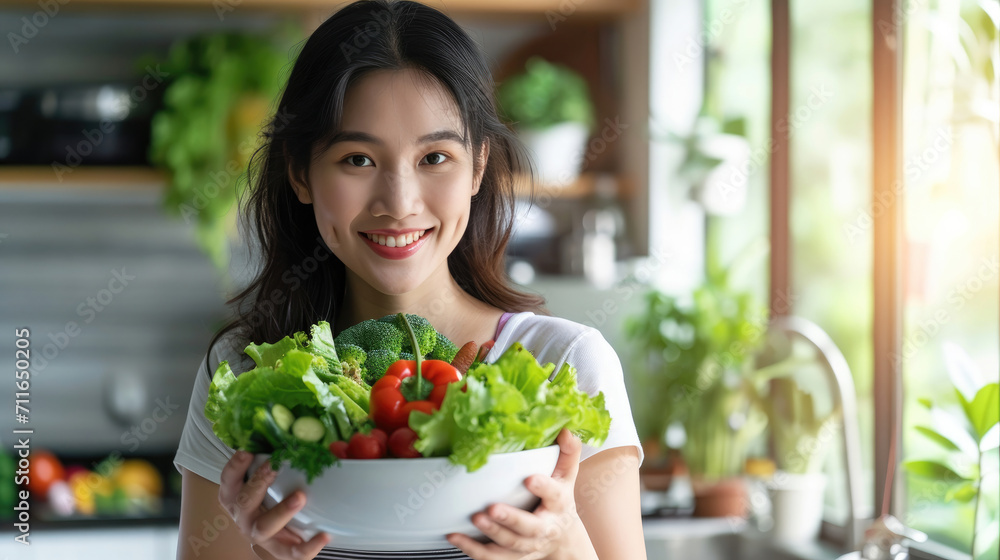 Portrait of Asian attractive woman hold salad bowl and look at camera. Beautiful sport girl in sportswear enjoy eat clean vegetables after exercise for health in house. Diet and Healthy food concept. Portrait of Asian attractive woman hold salad bowl and look at camera. Beautiful sport girl in sportswear enjoy eat clean vegetables after exercise for health in house. Diet and Healthy food concept.