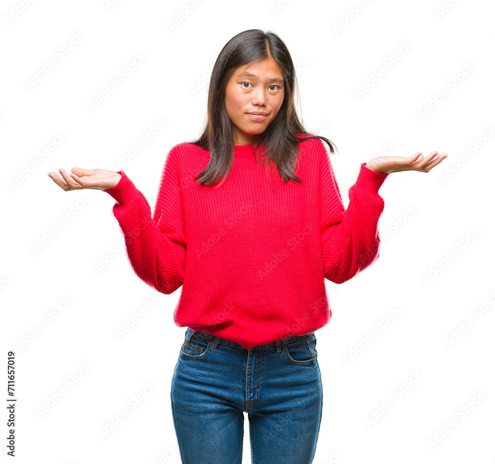 Young asian woman wearing winter sweater over isolated background clueless and confused expression with arms and hands raised. Doubt concept. Young asian woman wearing winter sweater over isolated background clueless and confused expression with arms and hands raised. Doubt concept.