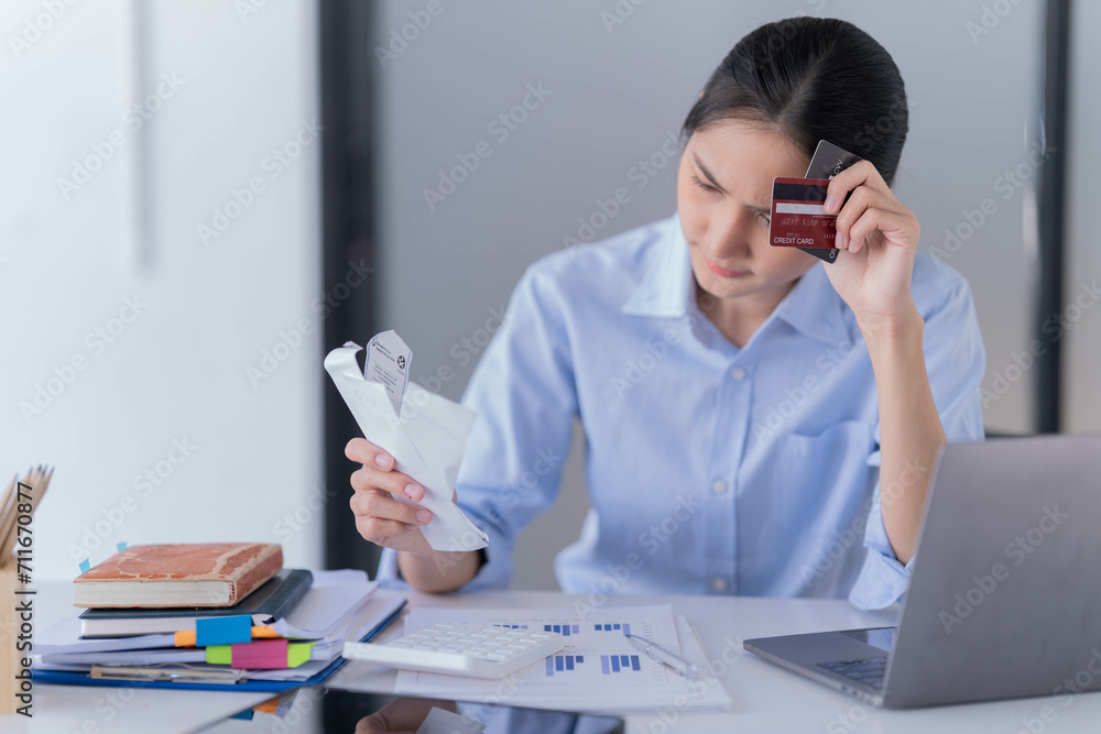 Asian businesswoman sitting in the office and be serious with her credit card bill. Asian businesswoman sitting in the office and be serious with her credit card bill.