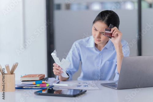 A beautiful young Asian woman holding file document working in the office and reading the notebook on the Dest. 