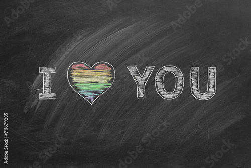I love you. Inscription in chalk on the blackboard with rainbow heart. LGBT, LGBTQIA rights and gender equality concept. Pride month. Declaration of love, acceptance of feelings, giving love.