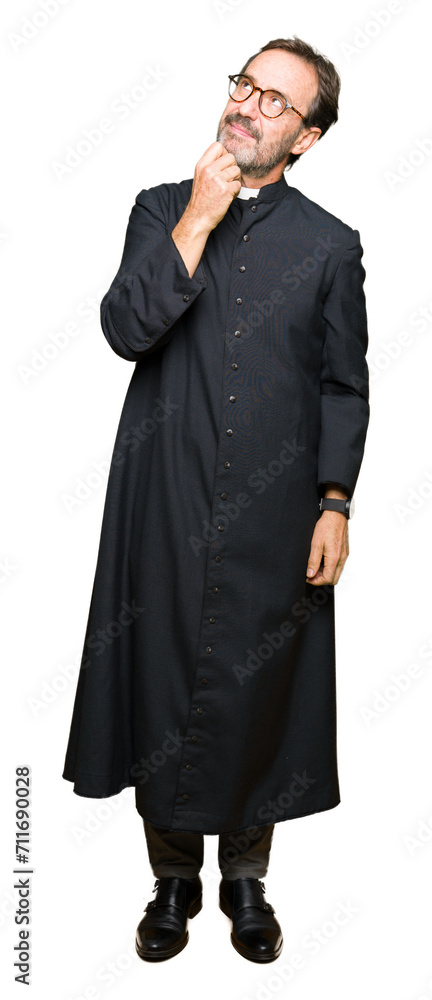 Middle age priest man wearing catholic robe with hand on chin thinking about question, pensive expression. Smiling with thoughtful face. Doubt concept. Middle age priest man wearing catholic robe with hand on chin thinking about question, pensive expression. Smiling with thoughtful face. Doubt concept.