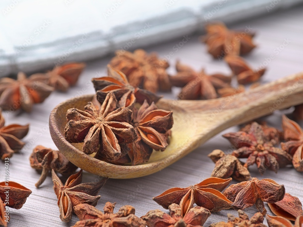 Dried star anise in a spoon and on a table. Dried star anise in a spoon and on a table.