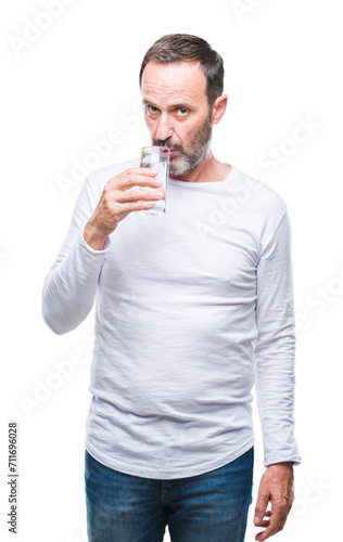 Middle age hoary senior man drinking glass of water over isolated background with a confident expression on smart face thinking serious © Krakenimages.com
