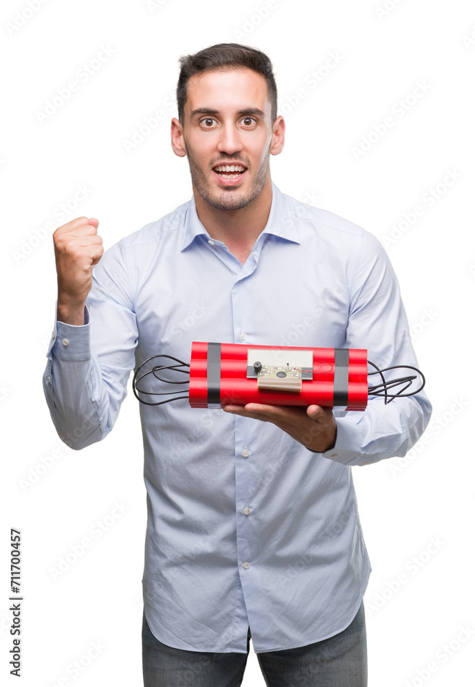 Handsome young business man holding an alarm clock bomb screaming proud and celebrating victory and success very excited, cheering emotion