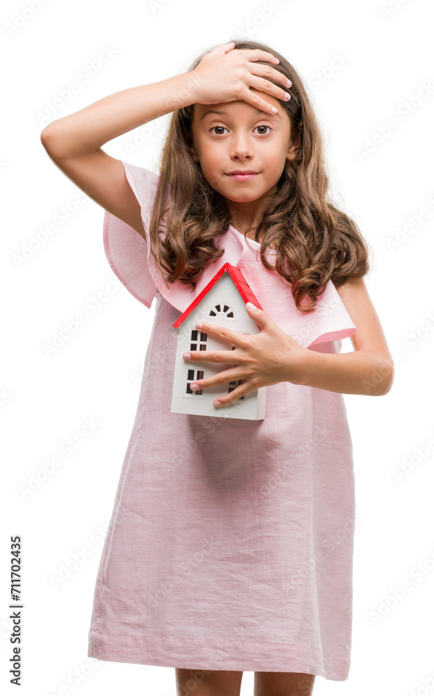 Brunette hispanic girl holding little house stressed with hand on head, shocked with shame and surprise face, angry and frustrated. Fear and upset for mistake. Brunette hispanic girl holding little house stressed with hand on head, shocked with shame and surprise face, angry and frustrated. Fear and upset for mistake.