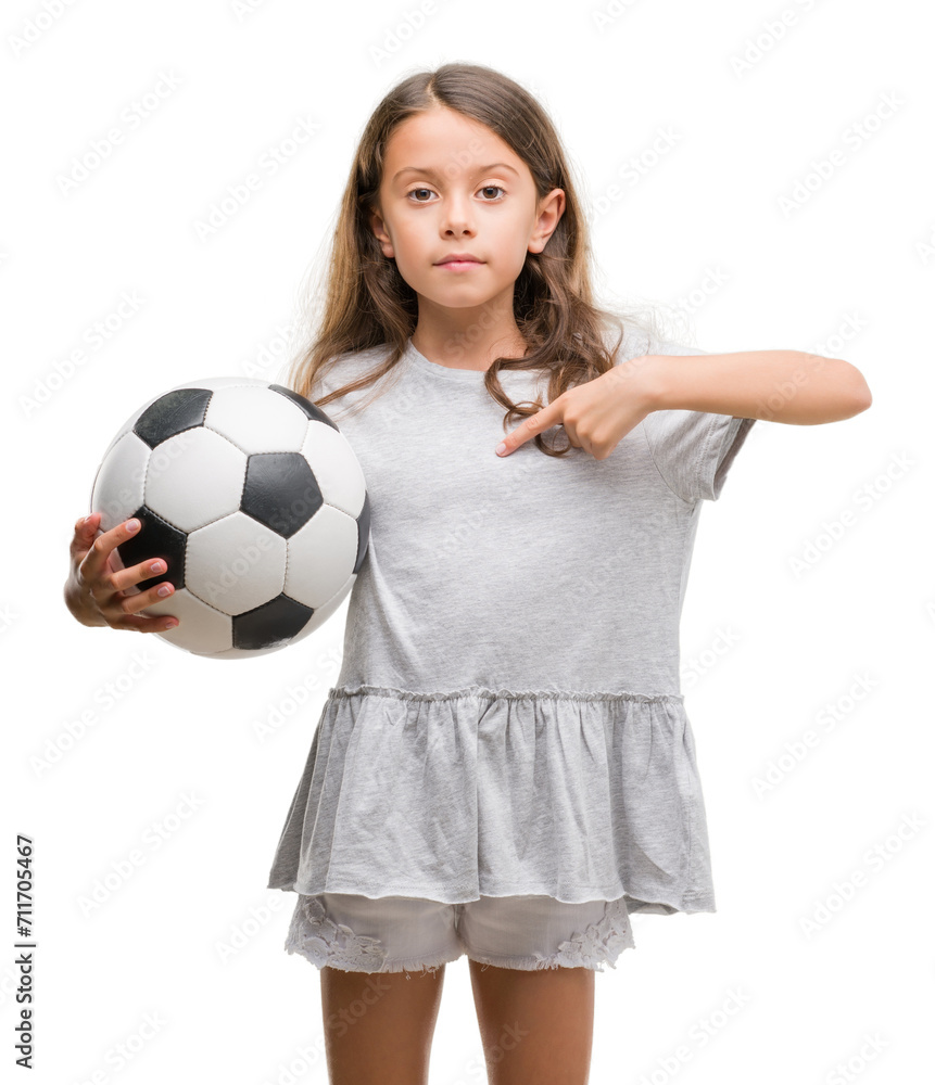 Brunette hispanic girl holding soccer football ball with surprise face pointing finger to himself Brunette hispanic girl holding soccer football ball with surprise face pointing finger to himself