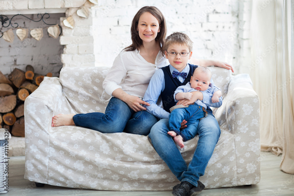 Fototapeta premium Happy mother with her children having fun in living room