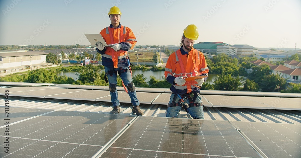 engineer man contractor worker architect construction manager in uniform and hardhat work to maintenance checking an operation and efficiency performance of photovoltaic solar panels on roof