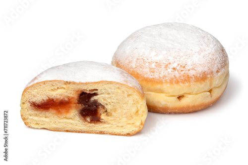 Whole and halved fresh baked Berliner donuts covered with sugar close up on white background