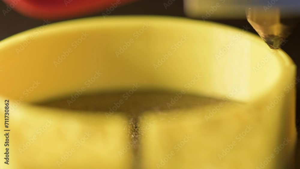 3D printer printing a part made of yellow plastic, close-up view 3D printer printing a part made of yellow plastic, close-up view