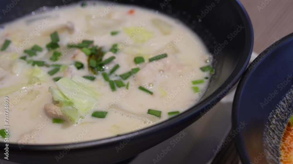 Close-up plates with thai soups tom kha with chicken and tom yum with seafood. Close-up plates with thai soups tom kha with chicken and tom yum with seafood.