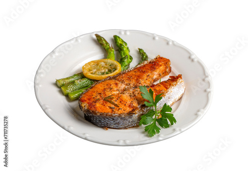 Grilled, baked salmon served on a plate with asparagus and potatoes.