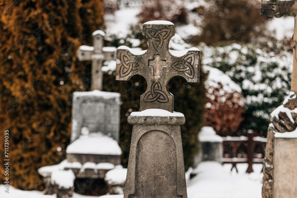 Antique memorial headstones in the snow on a cemetery