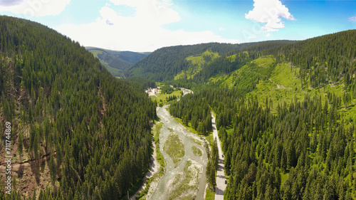 Aerial panorama of Lotru mountains. The forests near the road in the background have been cut down by the logging companies. A rapid river flows nearby. Carpathia, Romania. photo