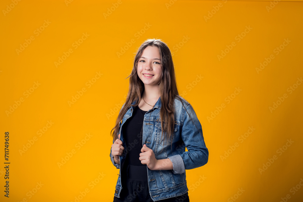 Fototapeta premium Smiling girl over yellow background. Emotion concept