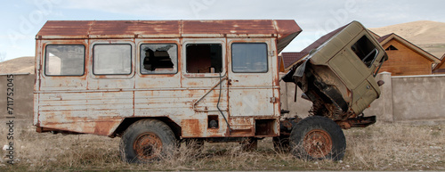 An old truck abandoned on the road with a rusty booth for transporting passengers