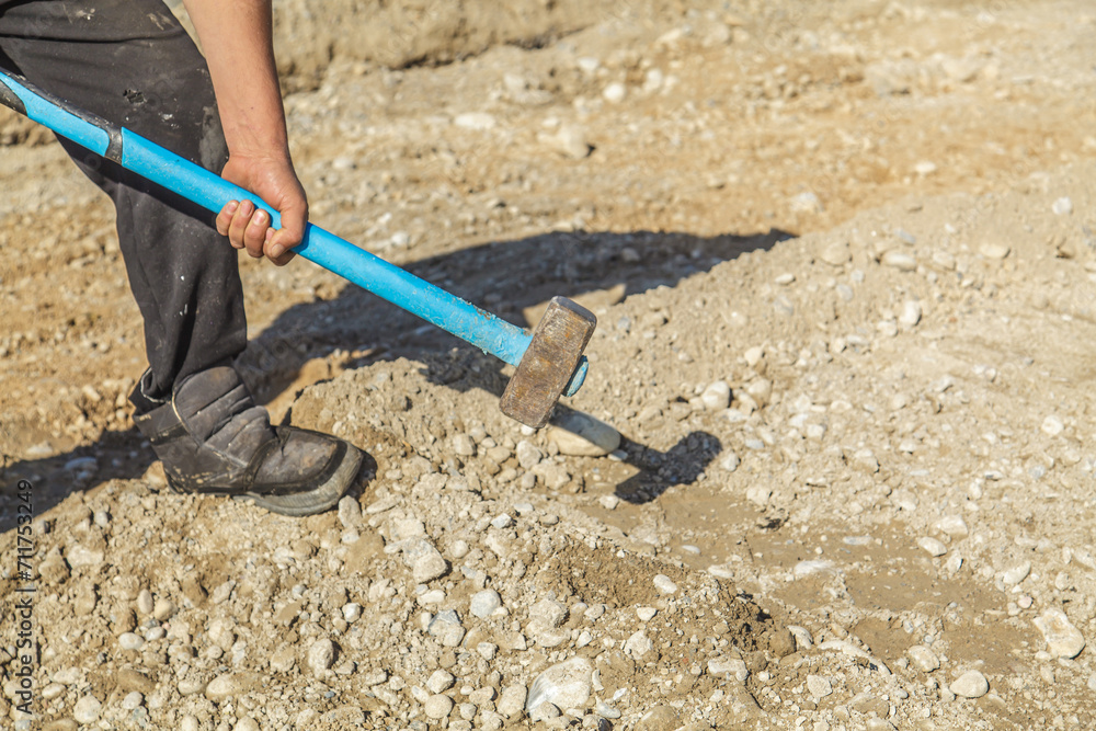 A builder holds a heavy hammer in his hands. Destroying something with force and fury A builder holds a heavy hammer in his hands. Destroying something with force and fury