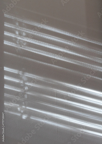 Sunlight through blinds cast on the wall