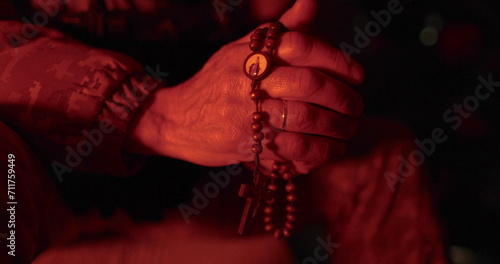 Soldiers pray with rosaries in their hands. Close-up of hands of vicar with rosary during prayer. They prayed for military time. Man prays. photo