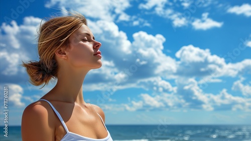 Serene woman enjoying freedom by the sea under a blue sky