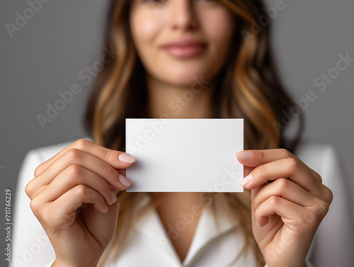 a businesswoman holding up a blank business card