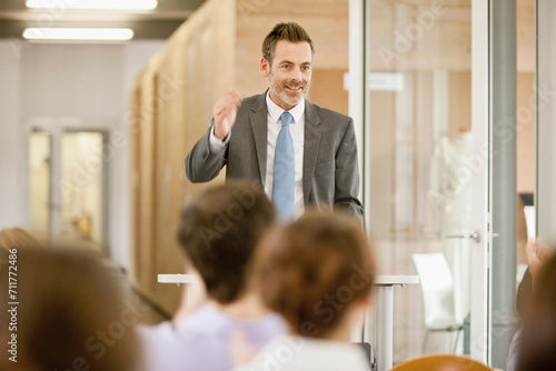 Motivational speaker and business coach holding a business coaching seminar for young professionals at a start-up business.