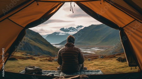 shot inside a tent overlooking the mountains, using the tent opening as a natural shot, the hiker's legs positioned to emphasize their connection to the mountain valley.