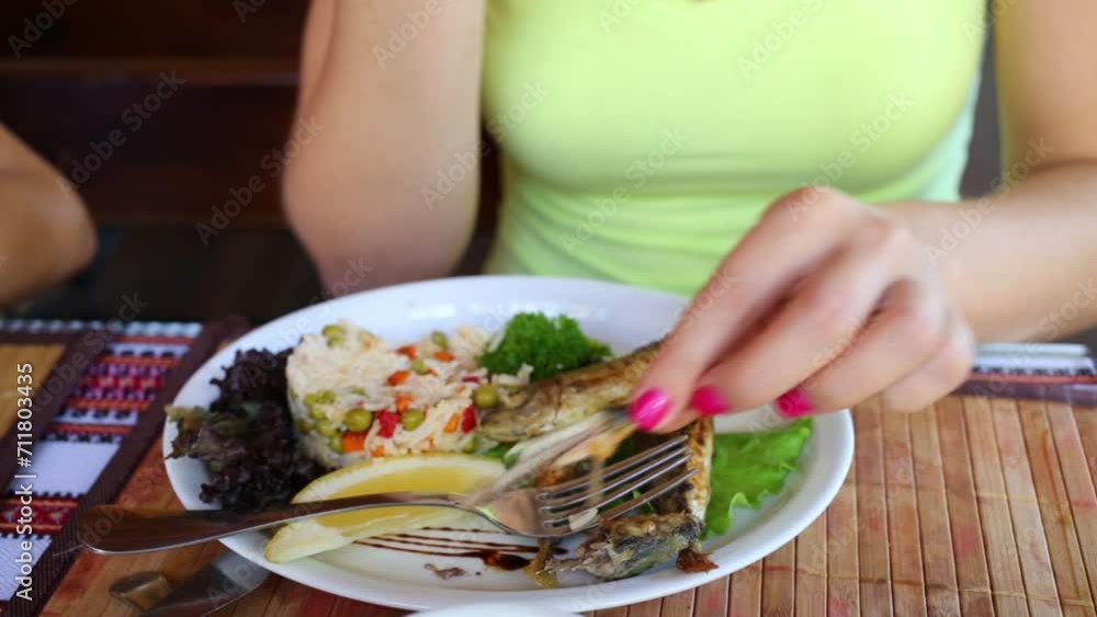 Rice with vegetables and fresh grilled fish on plate and hands Rice with vegetables and fresh grilled fish on plate and hands