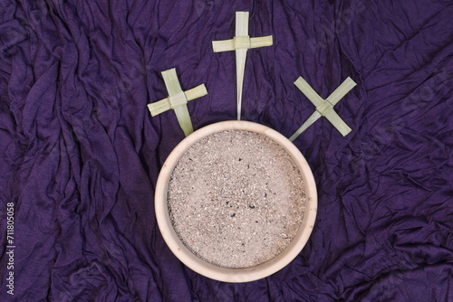 Three palm crosses and ash on purple background. Ash Wednesday concept.