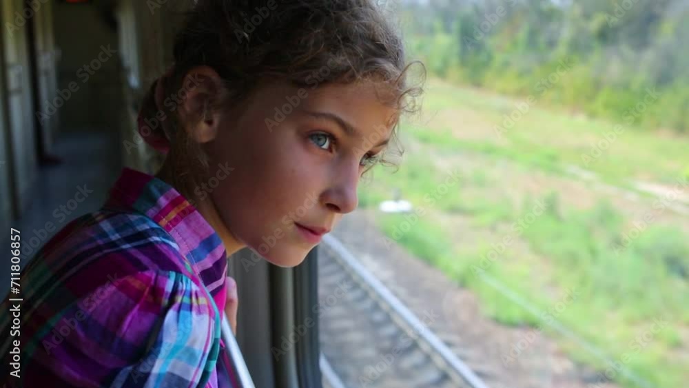 Pretty curly girl looks at window in moving train at summer Pretty curly girl looks at window in moving train at summer