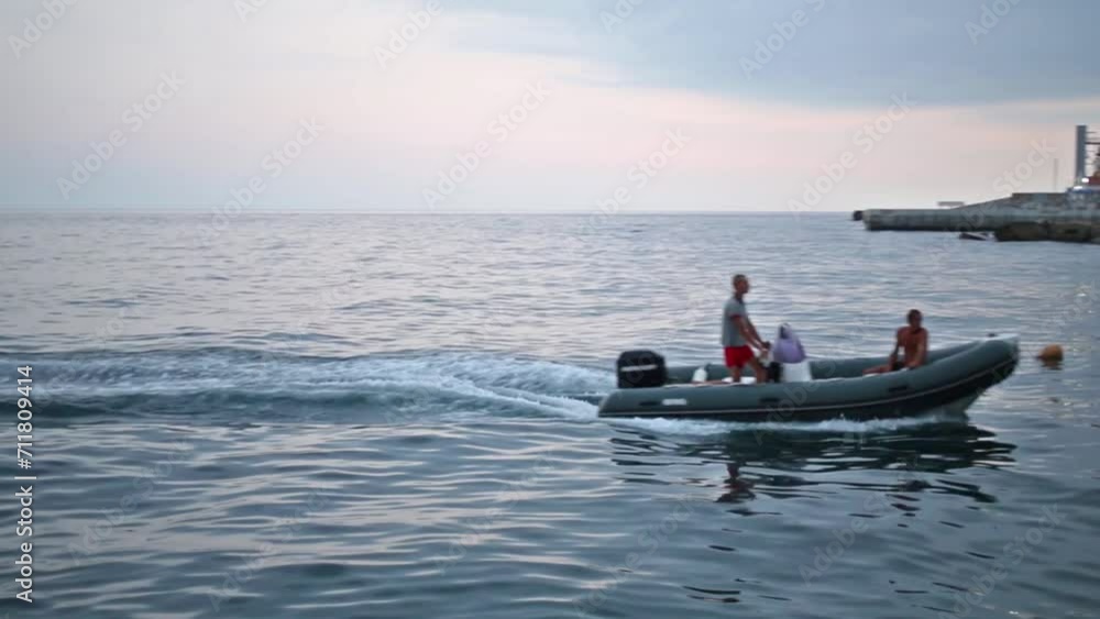 Two men are floating on motor boat in the sea. Two men are floating on motor boat in the sea.