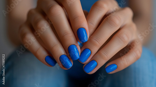 Female hand model with nail polish on her fingernails. Blue nail manicure with gel polish made at luxury beauty salon. 