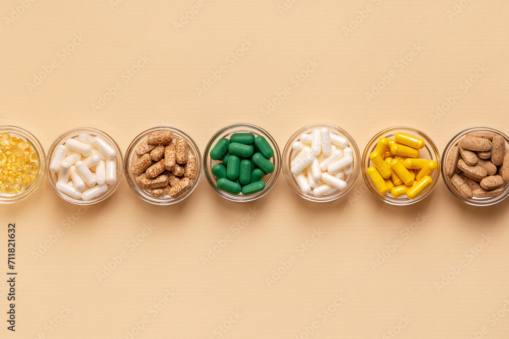 Tablets, capsules, pills, food supplements, minerals in small plates from above on a light beige background. Meds and vitamins to avoid illnesses to have a good health. Prevention of illness. Tablets, capsules, pills, food supplements, minerals in small plates from above on a light beige background. Meds and vitamins to avoid illnesses to have a good health. Prevention of illness.