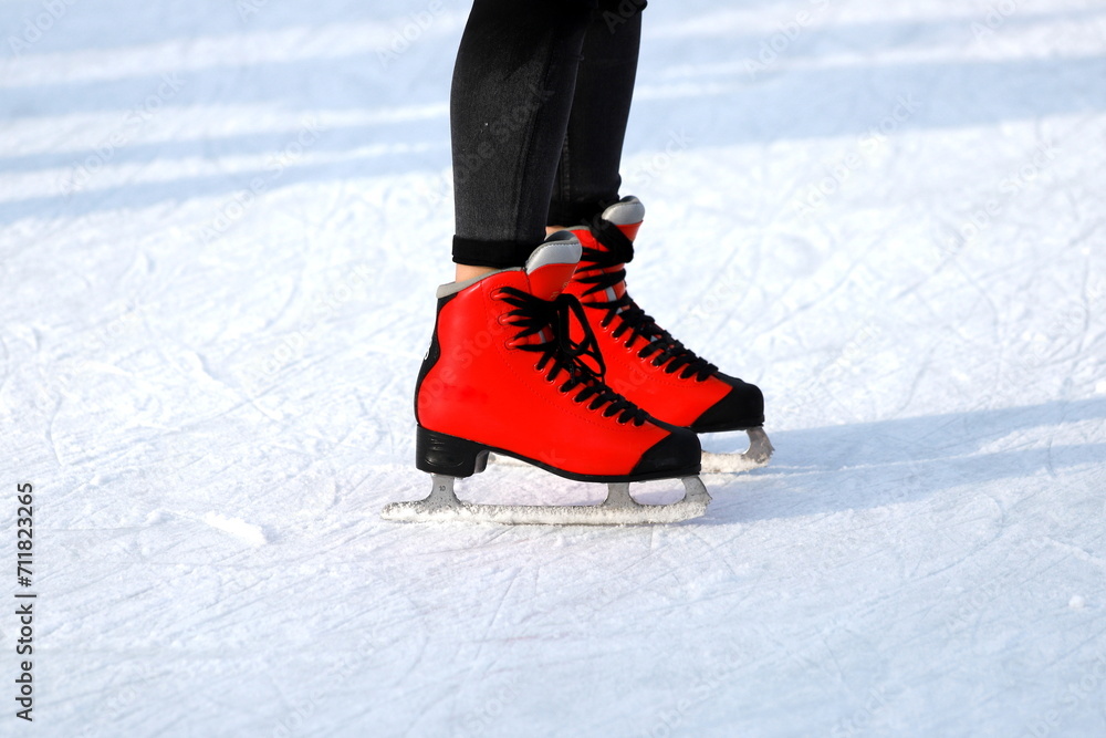 Naklejka premium Winter skating rink. Red skates skate on the ice. Active family sport during the winter holidays and cold season.