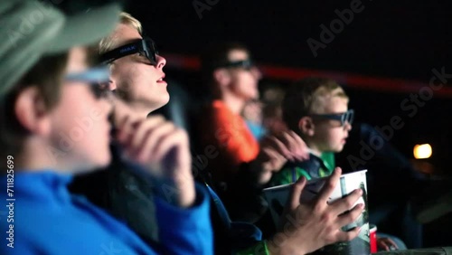 Three boys and theirs father watch a movie in 3D glasses  photo