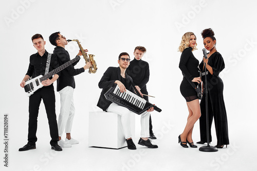 International group of musicians on a white background, guitarist, drummer, soloists, saxophonist. Copy space, relkama for musical instruments.