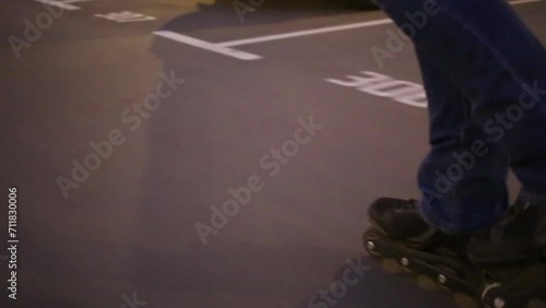 Legs of woman in jeans roller skating on street at summer night photo