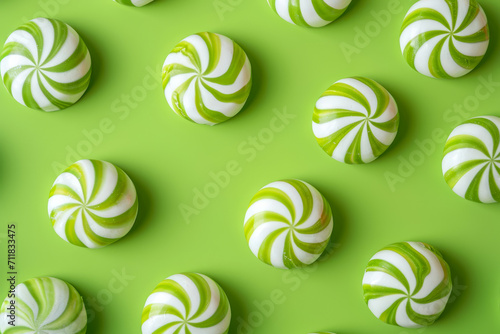 green striped peppermint candies on vibrant green background photo