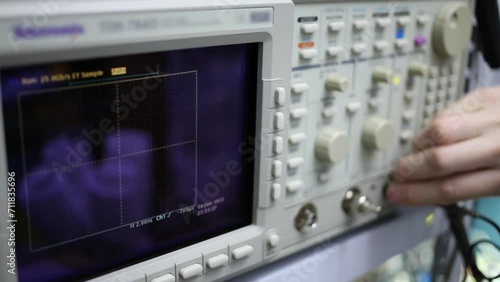 Digital oscilloscope and male hand pushes buttons for setting photo