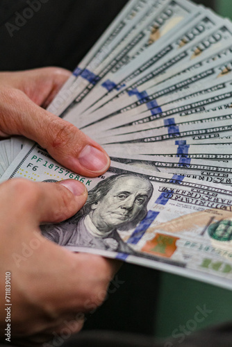 Close up view of hand holding dollar banknotes.