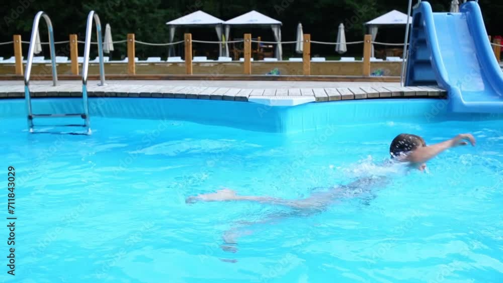 Little boy in swimming goggles swims at aquapark pool. Little boy in swimming goggles swims at aquapark pool.