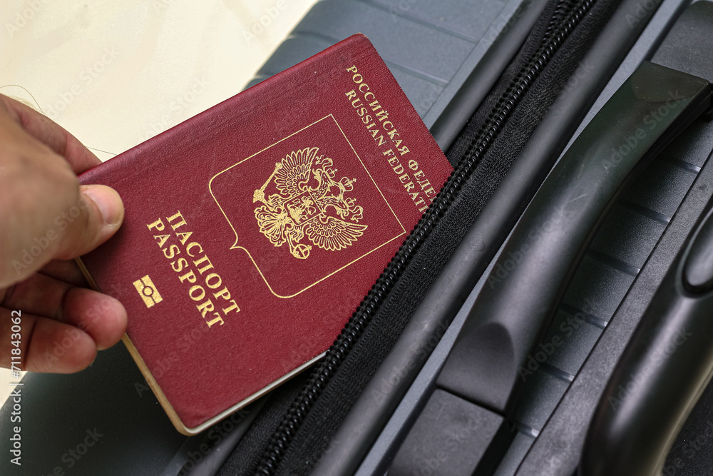 Closeup view of russian passport and grey suitcase. Closeup view of russian passport and grey suitcase.