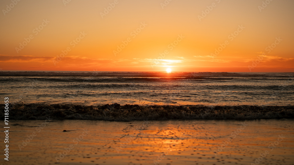 Fototapeta premium Beautiful beach with rays of sun reflected in the foam of the waves