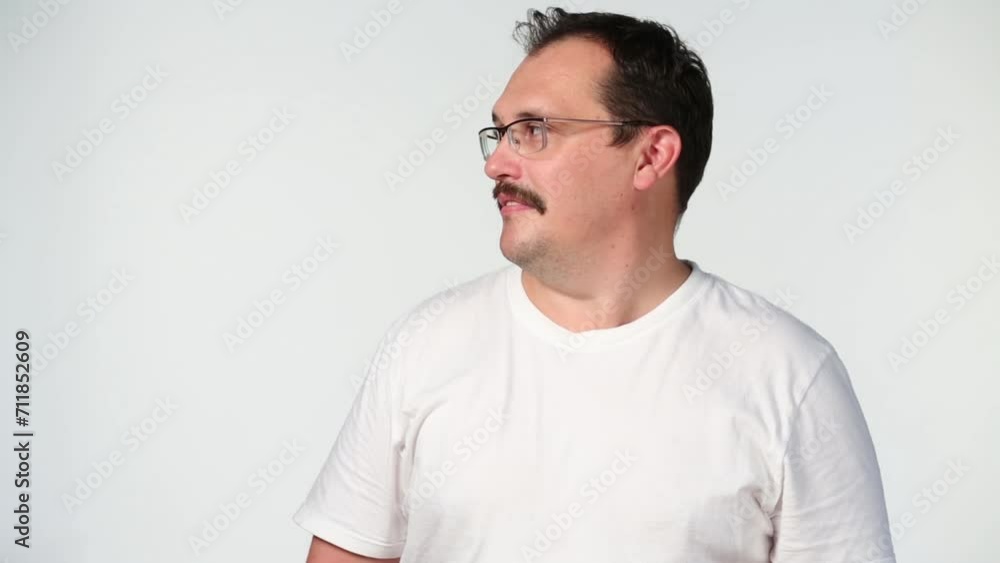 Middle-aged man in white shirt turns his head and touches hair Middle-aged man in white shirt turns his head and touches hair