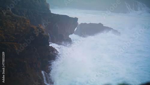 Powerful waves breaking cliff making explosion. Closeup dramatic ocean washing