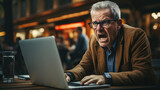 angry senior director with laptop in cafe