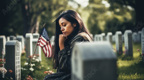 Woman praying in a memorial cemetery, for war soldiers