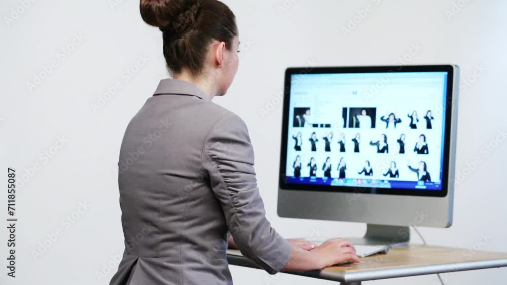 businesswoman sitting at desk and looking at computer screen businesswoman sitting at desk and looking at computer screen