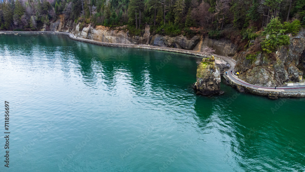 Fototapeta premium Seawall wrapping around Stanley park. The concrete pavement winds against the bare rock cliff. 